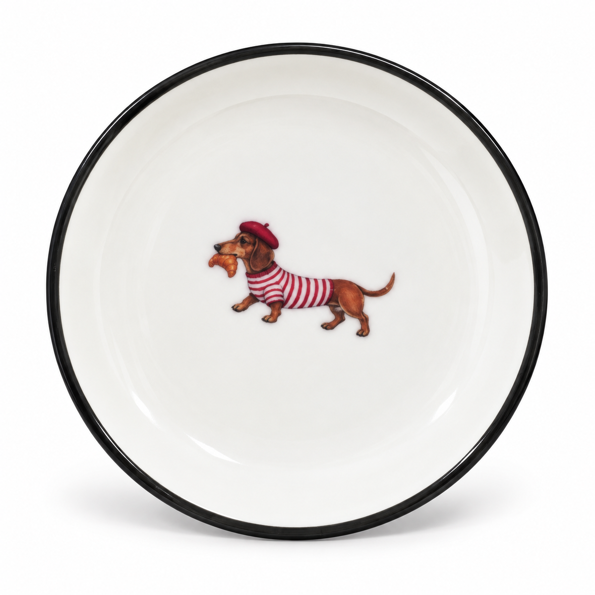 A little Parisian moment for your favourite things. This 4-inch ceramic trinket tray features an adorable dachshund in a striped top and beret, carrying a fresh croissant.

Finished with a classic black rim, it’s perfect for rings, earrings, or tiny keepsakes—and made for anyone who loves Paris, pups, and beautiful little details.